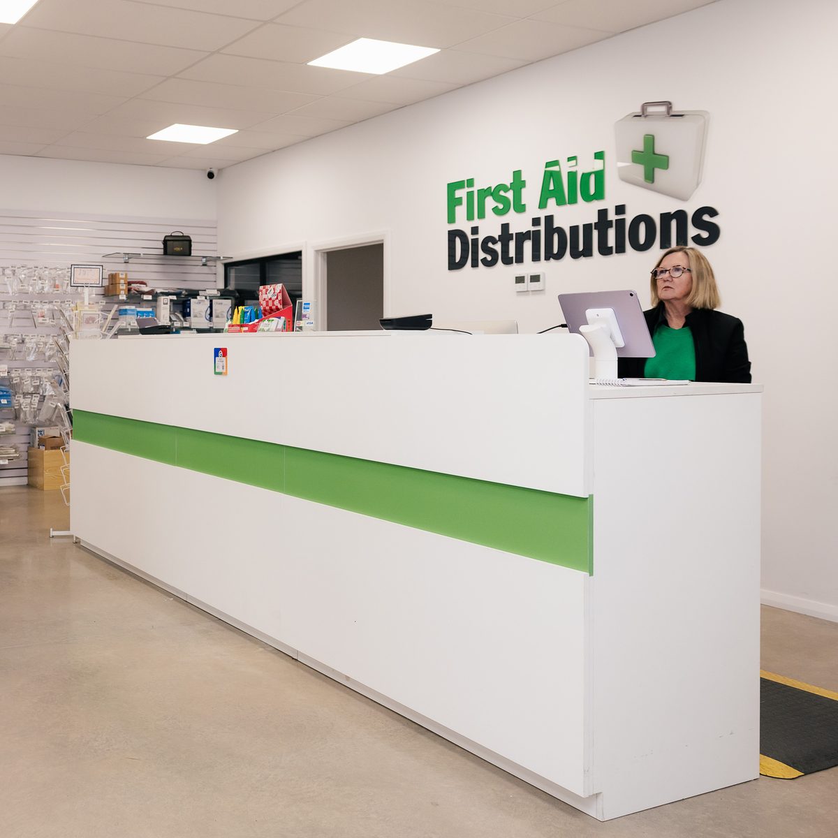The counter of the First Aid Distributions store in East Bendigo, home of Comfort First, with Kim Hando behind it